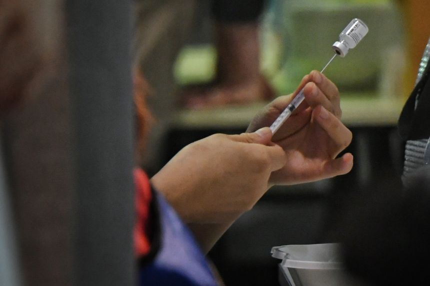  ​A health worker preparing a Covid-19 vaccine shot at Tanjong Pagar Community Club, on June 3, 2021.  PHOTO ST FILE 