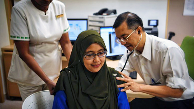 Professor Julian Thumboo, a senior consultant at Singapore General Hospital's Department of Rheumatology and Immunology, examining lupus patient Kartina Mohamad on Tuesday (Sept 26).  ST PHOTO MARK CHEONG